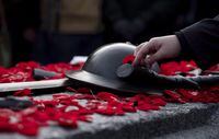 People lay poppies on the Tomb of the Unknown Soldier at the National War Memorial after Remembrance Day ceremonies, in Ottawa, Sunday, Nov. 11, 2018. THE CANADIAN PRESS/Justin Tang