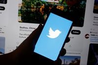 A Twitter logo is displayed on a mobile phone near a computer screen showing promoted tweets on China, in this illustration picture taken September 8, 2022. REUTERS/Florence Lo/Illustration
