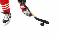 File Number: 2361665Close-up on hockey player legs, skates.Ice Hockey.  Puck. Credit: iStockphoto(Royalty-Free)