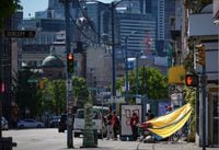 Youth struggling with mental health or addiction will have access to a new outreach centre in Vancouver's Downtown Eastside, providing what the government says will be life-saving support. A tarp is seen draped between a building and a shopping cart to provide shade from the sun in the Downtown Eastside of Vancouver, B.C., Saturday, May 13, 2023. THE CANADIAN PRESS/Darryl Dyck