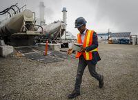 Apoorv Sinha, centre, CEO of Carbon Upcycling, carries a piece of equipment at the company's facility in Calgary, Alta., Tuesday, July 20, 2021. Jeff McIntosh for The Globe and Mail