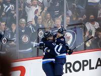 Winnipeg Jets' Adam Lowry (17) and Mark Scheifele (55) celebrates Scheifeles third goal of the game against the Vancouver Canucks during third period NHL action in Winnipeg, Thursday, December 29, 2022. THE CANADIAN PRESS/John Woods