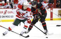 New Jersey Devils center Jack Hughes (86) plays the puck against Ottawa Senators right wing Drake Batherson (19) during the second period of an NHL hockey game, Saturday, March 25, 2023, in Newark, N.J. (AP Photo/Noah K. Murray)