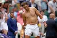 FILE - Spain's Rafael Nadal sports tape on his stomach following a medical timeout as he plays Taylor Fritz of the US in a men's singles quarterfinal match on day ten of the Wimbledon tennis championships in London, Wednesday, July 6, 2022. Nadal has withdrawn from the upcoming hard-court tournament in Montreal because of the abdominal injury that caused him to pull out of Wimbledon ahead of the semifinals. The Spaniard had been 19-0 in Grand Slam matches this year when he decided the injury was too much at Wimbledon.(AP Photo/Kirsty Wigglesworth, File)