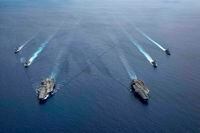 In this photo provided by U.S. Navy, the USS Ronald Reagan (CVN 76) and USS Nimitz (CVN 68) Carrier Strike Groups steam in formation, in the South China Sea, Monday, July 6, 2020. China on Monday, July 6, accused the U.S. of flexing its military muscles in the South China Sea by conducting joint exercises with two U.S. aircraft carrier groups in the strategic waterway.(Mass Communication Specialist 3rd Class Jason Tarleton/U.S. Navy via AP)