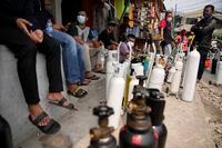 In this July 5, 2021, file photo, people queue up to refill their oxygen tanks at a filling station in Jakarta, Indonesia. Images of bodies burning in open-air pyres during the peak of the pandemic in India horrified the world in May, but in the last two weeks Indonesia and two other Southeast Asian nations have surpassed India’s peak per capita death rate as a new coronavirus wave tightens its grip on the region. (AP Photo/Dita Alangkara, File)