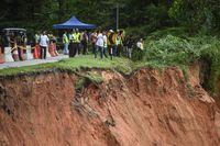 People inspect the damage after a landslide in Batang Kali, Selangor on December 16, 2022. - Nearly 20 people, including four children, were killed when a landslide struck a campsite at a Malaysian farm on Friday, officials said, with rescuers scouring the muddy terrain for those still missing. (Photo by Arif Kartono / AFP) (Photo by ARIF KARTONO/AFP via Getty Images)