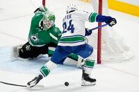 Dallas Stars goaltender Scott Wedgewood defends against a shot by Vancouver Canucks' Pius Suter (24) during the third period of an NHL hockey game in Dallas, Thursday, Dec. 21, 2023. (AP Photo/Tony Gutierrez)