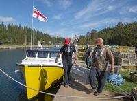 Members of the Potlotek First Nation carry bait boxes as they prepare to head out into St. Peters Bay from the wharf in St. Peter’s, N.S., to participate in a self-regulated commercial lobster fishery on Thursday, Oct. 1, 2020, which is Treaty Day. The Mi'kmaq First Nation in Cape Breton is criticizing the seizure of 37 lobster traps set today by a fisher from their community. THE CANADIAN PRESS /Andrew Vaughan