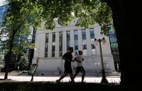 Joggers run past the Bank of Canada building in Ottawa June 5, 2012.