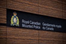 The RCMP logo is seen outside Royal Canadian Mounted Police "E" Division Headquarters, in Surrey, B.C., on Friday April 13, 2018.&nbsp;Two people have died in a house fire in North Vancouver. A statement from North Vancouver RCMP says the blaze engulfed the single family home at about 3 a.m. THE CANADIAN PRESS/Darryl Dyck