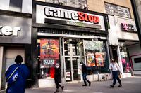 Pedestrians pass a GameStop store on 14th Street at Union Square, Thursday, Jan. 28, 2021, in the Manhattan borough of New York. Robinhood and other online trading platforms are moving to restrict trading in GameStop and other stocks that have soared recently due to rabid buying by smaller investors. GameStop stock has rocketed from below $20 to more than $400 this month as a volunteer army of investors on social media challenged big institutions who has placed market bets that the stock would fall. (AP Photo/John Minchillo)