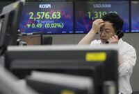 A currency trader talks on the phone near screens showing the Korea Composite Stock Price Index (KOSPI), top left, and the foreign exchange rate between U.S. dollar and South Korean won at the foreign exchange dealing room of the KEB Hana Bank headquarters in Seoul, South Korea, Thursday, June 1, 2023. Asian benchmarks were mostly higher Thursday after the U.S. House of Representatives approved a debt ceiling and budget cuts package, avoiding a default crisis. (AP Photo/Ahn Young-joon)
