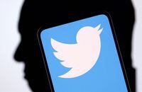 FILE PHOTO: Twitter logo and Elon Musk silhouette are seen in this illustration taken, December 19, 2022. REUTERS/Dado Ruvic/Illustration