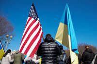 A demonstrator holds U.S. and Ukrainian flags during a "Stand with Ukraine" rally against the Russian invasion of Ukraine, in front of the White House in Washington, U.S., February 28, 2022. REUTERS/Elizabeth Frantz