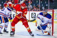 Sep 28, 2022; Calgary, Alberta, CAN; Calgary Flames center Mitch McLain (75) controls the puck in front of Edmonton Oilers goaltender Stuart Skinner (74) during the third period at Scotiabank Saddledome. Mandatory Credit: Sergei Belski-USA TODAY Sports