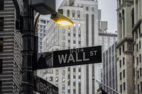 A street light brightens a Wall Street sign outside the New York Stock Exchange, Oct. 3, 2022, in New York.