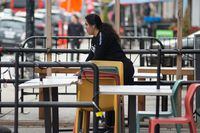 A worker organizes chairs and tables on the patio of a restaurant on College St., Toronto, Thursday, October 28, 2021. Restaurants across Canada are cutting back hours and tightening up menus as persistent labour shortages and spiking costs threaten to derail the industry's comeback from crushing pandemic restrictions.THE CANADIAN PRESS/Eduardo Lima