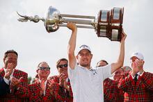 May 28, 2023; Fort Worth, Texas, USA; Emiliano Grillo holds the Champions Trophy in the air during the final round of the Charles Schwab Challenge golf tournament. Mandatory Credit: Raymond Carlin III-USA TODAY Sports