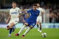 Chelsea's Enzo Fernandez is challenged by AFC Wimbledon's James Tilley during the English League Cup second round soccer match between Chelsea and AFC Wimbledon at Stamford Bridge stadium in London, Wednesday, Aug. 30, 2023. (AP Photo/Kin Cheung)