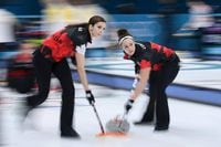 Canada's Lisa Weagle (left) and Joanne Courtney brush in front of the stone during the curling women's round robin session between Canada and China at the Gangneung Curling Centre on February 20, 2018.