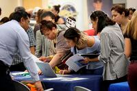 FILE - In this Sept. 18, 2019, file photo job applicants looks at jobs available at Florida International University during a job fair in Miami. On Wednesday, Jan. 8, 2020, payroll processor ADP reports on how many jobs its survey estimates U.S. companies added in December. (AP Photo/Lynne Sladky, File)
