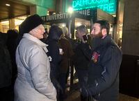 Jeremy MacKenzie, right, a Canadian military veteran who served in Afghanistan, talks with an unidentified woman outside the venue where Omar Khadr, the former child soldier is speaking in Halifax on Monday, February 10, 2020.The founder of the online group "Diagolon" remains in custody after being denied release following a bail hearing in Saskatchewan.&nbsp;THE CANADIAN PRESS/Andrew Vaughan