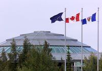 From left, the Territorial flag, Canadian flag and the flag of the State of Alaska fly outside the NWT Legislative Assembly, in Yellowknife, Tuesday Aug. 21, 2001. The chief public health officer for the Northwest Territories has declared a workplace COVID-19 outbreak at the legislature building in Yellowknife. THE CANADIAN PRESS/Chuck Stoody