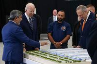 FILE — Sanjay Mehrotra, left, Micron Technology’s chief executive, gestures at a model of the company’s planned manufacturing site while speaking with President Joe Biden and Sen. Chuck Schumer (D-N.Y.), in Syracuse, N.Y., on Oct. 27, 2022. Schumer, the Senate majority leader, helped deliver billions of dollars in federal funding for semiconductors; now he’s pushing for his state to reap benefits. (Kenny Holston/The New York Times)