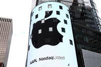 FILE PHOTO: An electronic screen displays the Apple Inc. logo on the exterior of the Nasdaq Market Site following the close of the day's trading session in New York City, New York, U.S., August 2, 2018. REUTERS/Mike Segar