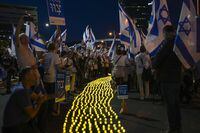 Israelis protest against plans by Prime Minister Benjamin Netanyahu's government to overhaul the judicial system, light candles in Tel Aviv, Israel, Saturday, April 22, 2023. (AP Photo/Tsafrir Abayov)