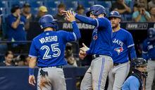Toronto Blue Jays' Daulton Varsho (25) and Kevin Kiermaier, right, congratulate Danny Jansen, who had hit a two-run home run off Tampa Bay Rays Christian Bethancourt during the ninth inning of a baseball game Tuesday, May 23, 2023, in St. Petersburg, Fla. (AP Photo/Steve Nesius)