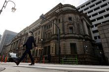 FILE PHOTO: A man walks in front of the headquarters of Bank of Japan in Tokyo, Japan, January 18, 2023.   REUTERS/Issei Kato/File Photo