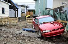 A car sits in the backyard of a house after a major spring flood hit Baie-Saint-Paul, Que., on Wednesday, May 3. Quebec's Public Security Department says water levels are declining across the province, but the spring flood season is not yet over. THE CANADIAN PRESS/Jacques Boissinot