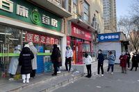 People wearing masks line up outside a pharmacy to buy products as coronavirus disease (COVID-19) outbreaks continue in Beijing, China December 6, 2022. REUTERS/Alessandro Diviggiano