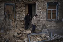 Oleksandra Hryhoryna, left, inspects her house which was damaged by shelling last fall in Kalynivske, Ukraine, Saturday, Jan. 28, 2023. (AP Photo/Daniel Cole)