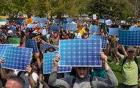 Activists display prints replicating solar panels during a rally to mark Earth Day at Lafayette Square, Washington, April 23, 2022.