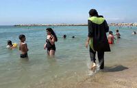 FILE - In this Aug.4 2016 file photo made from video, Nissrine Samali, 20, gets into the sea wearing a burkini, a wetsuit-like garment that also covers the head, in Marseille, southern France. France's top administrative body ruled Tuesday against allowing body-covering "burkini" swimwear in public pools for religious reasons. (AP Photo, File)