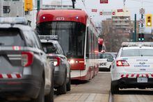 Police vehicles surround a TTC streetcar on Spadina Ave., in Toronto on Tuesday, January 24, 2023 after a stabbing incident. Police are expected to increase their presence on city transit following an uptick in violence incidents at subway stations across the city.THE CANADIAN PRESSArlyn McAdorey