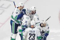 Vancouver Canucks players celebrate the win over the St. Louis Blues during the third period of a first round NHL Stanley Cup playoff hockey series in Edmonton, on Aug. 12, 2020.