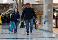People walk with shopping bags at Roosevelt Field mall in Garden City, New York, U.S., December 7, 2018. REUTERS/Shannon Stapleton/Files
