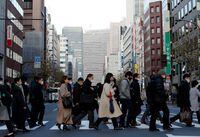 FILE PHOTO: Pedestrians wearing protective masks, following the coronavirus disease (COVID-19) outbreak, make their way during commuting hour at a business district in Tokyo, Japan, January 7, 2021. REUTERS/Kim Kyung-Hoon/File Photo