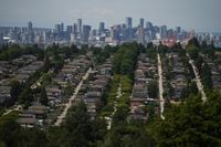 The downtown Vancouver skyline is seen in the distance beyond houses in Burnaby, B.C., on Wednesday, July 12, 2023. THE CANADIAN PRESS/Darryl Dyck
