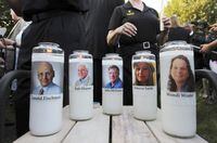 FILE - In this June 29, 2018, file photo, pictures of five employees of the Capital Gazette newspaper adorn candles during a vigil across the street from where they were slain in the newsroom in Annapolis, Md. A jury was selected on Friday, June 25, 2021, for the second phase of a trial for a man who killed the five people at the newspaper to decide whether he is criminally responsible due to his mental health. Jarrod Ramos pleaded guilty in 2019 to all 23 counts against him in the attack at the Capital Gazette nearly three years ago, but he has pleaded that he is not criminally responsible due to mental illness. (AP Photo/Jose Luis Magana, File)