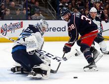Winnipeg Jets goalie David Rittich, left, stops a shot in front of Columbus Blue Jackets forward Boone Jenner during the second period of an NHL hockey game in Columbus, Ohio, Thursday, Feb. 16, 2023. (AP Photo/Paul Vernon)