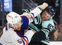 Edmonton Oilers left wing Dylan Holloway (55) and Seattle Kraken defenseman Vince Dunn (29) fight during the second period of an NHL hockey game Friday, Dec. 30, 2022, in Seattle. (AP Photo/Lindsey Wasson)