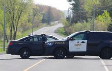 OPP vehicles block a road near the scene of a shooting where one Ontario Provincial Police officer was killed and two others were injured in the town of Bourget, Ont. on Thursday, May 11, 2023. THE CANADIAN PRESS/ Patrick Doyle