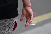 A man is seen smoking a cigarette in central London on June 9, 2022. - The age at which people can buy tobacco in England should rise by one each year until it becomes a "smoke-free" society, a government-commissioned review recommended Thursday. (Photo by JUSTIN TALLIS / AFP) (Photo by JUSTIN TALLIS/AFP via Getty Images)