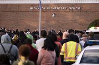 Students and police gather outside of Richneck Elementary School after a shooting, Friday, Jan. 6, 2023 in Newport News, Va. A shooting at a Virginia elementary school sent a teacher to the hospital and ended with “an individual” in custody Friday, police and school officials in the city of Newport News said.(Billy Schuerman/The Virginian-Pilot via AP)