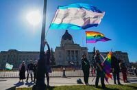 People hold pride flags while attending a rally against the Saskatchewan government's proposed legislation on pronoun policy in front of the Saskatchewan legislature in Regina on Oct. 10, 2023. THE CANADIAN PRESS/Heywood Yu